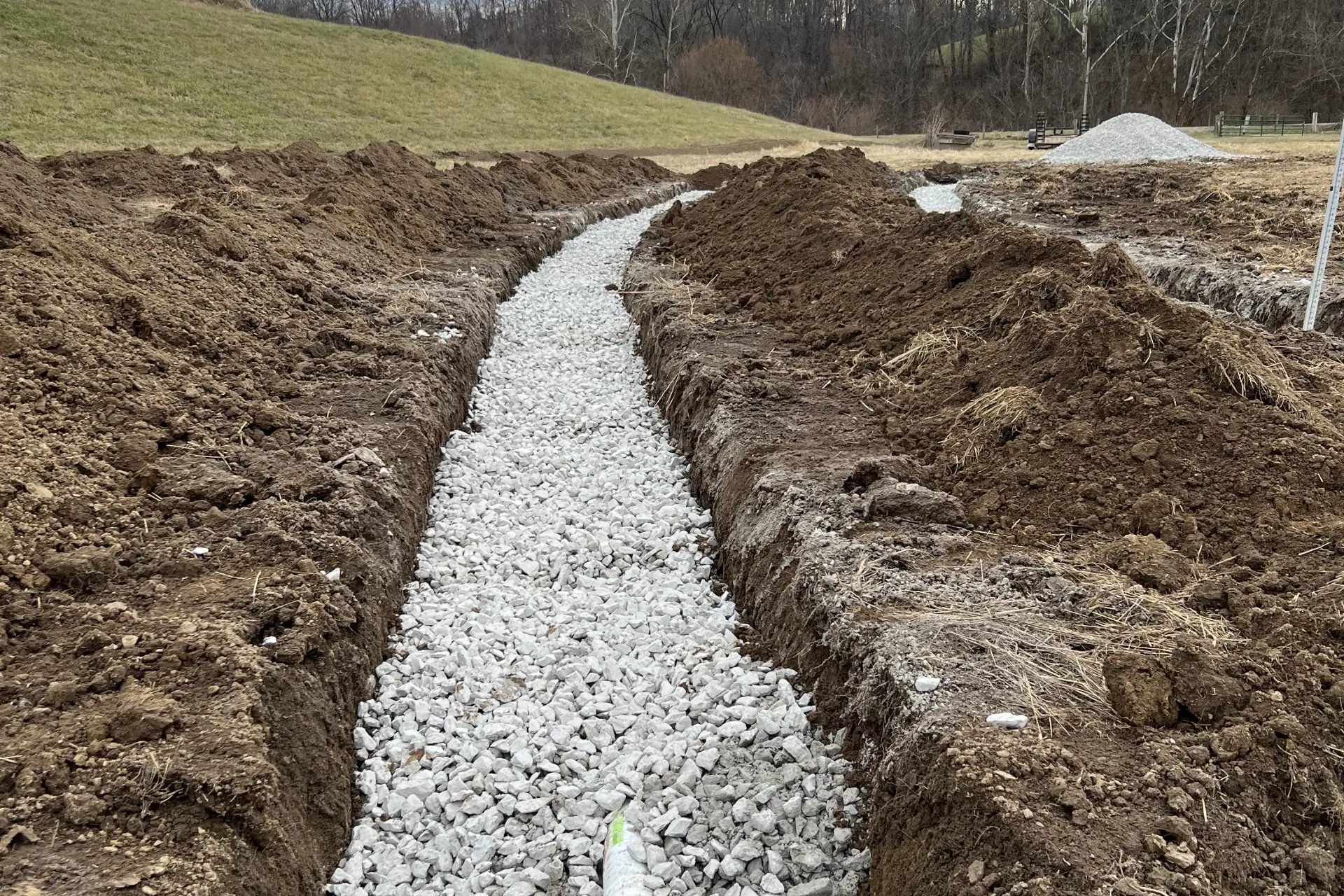 A trench with gravel and dirt in it